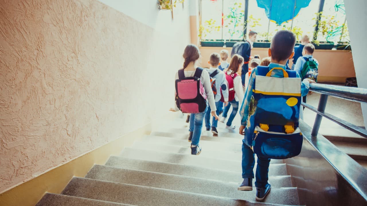 Schulkinder laufen eine Treppe abwärts