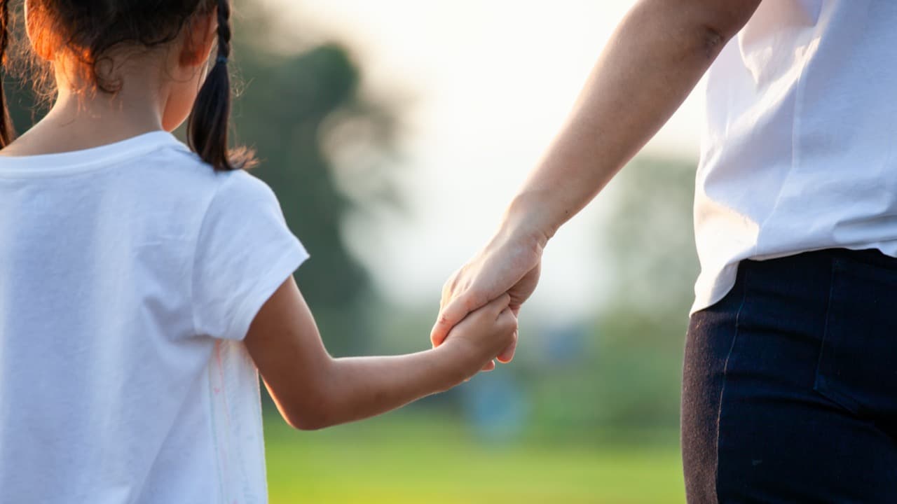 Woman holding a child's hand