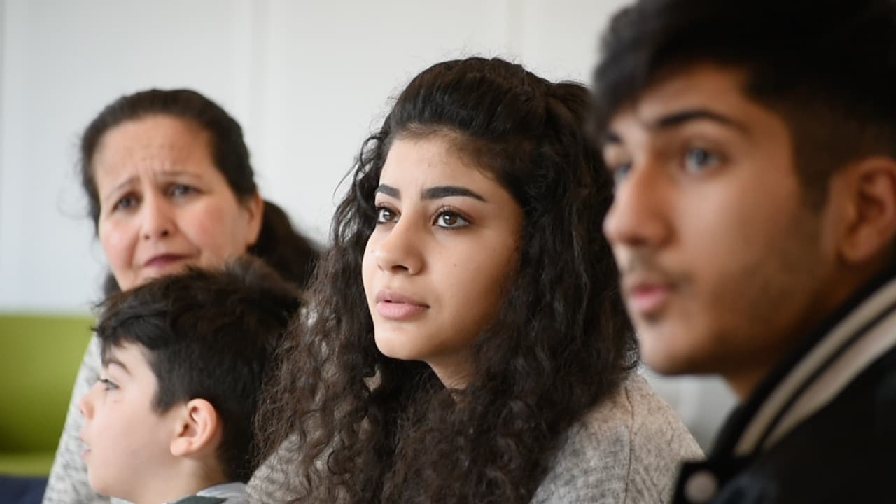 Four migrants from different age groups sitting next to one another
