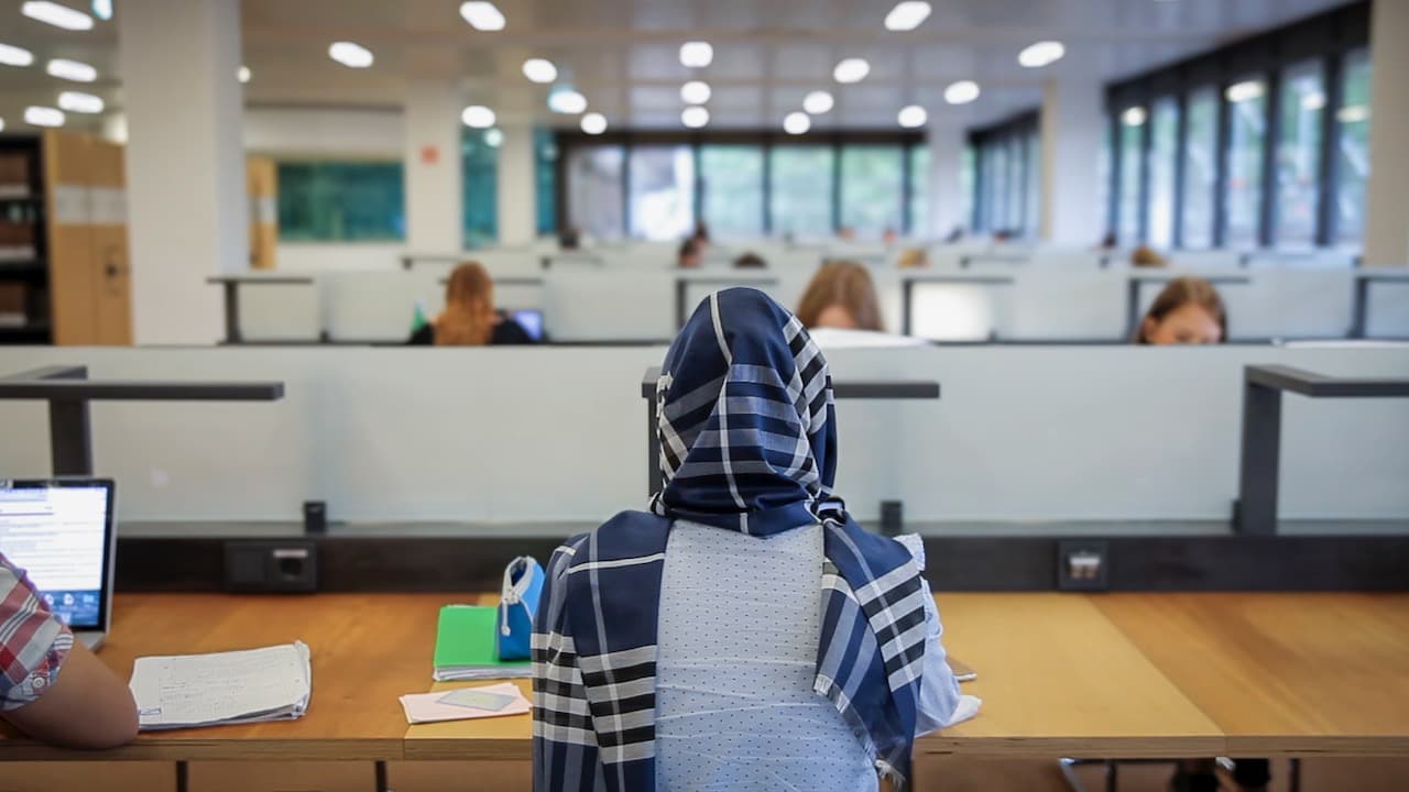 Women with scarf studying in library