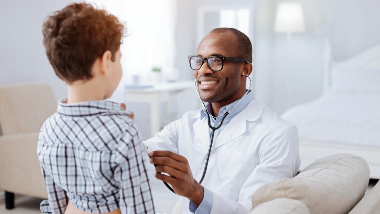 Smiling doctor examining a child