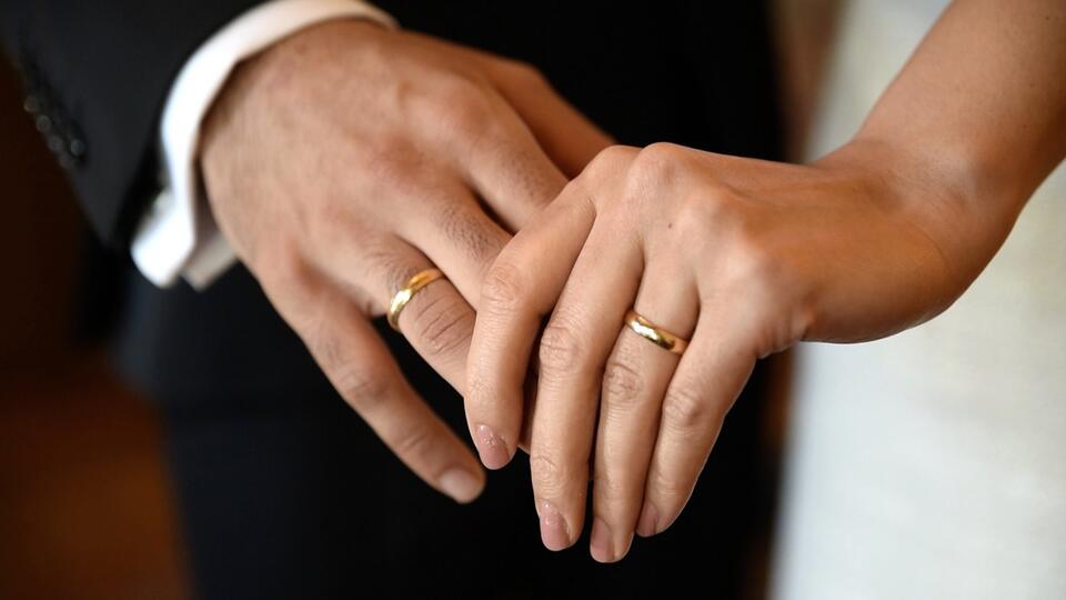 Das Bild zeigt die Hand eines Mannes und einer Frau.Beide tragen goldene Ehereinge. Sie halten sich an den Händen. 